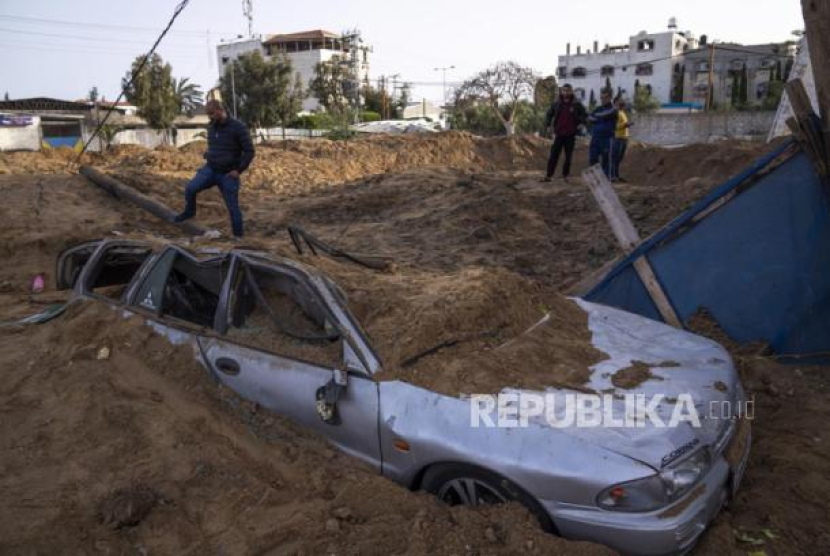  Warga Palestina memeriksa kerusakan akibat serangan udara Israel semalam di Kota Gaza, Jumat (7/4//2023). Militer Israel telah menyerang sasaran di Jalur Gaza, mendorong wilayah itu menuju kebakaran yang lebih luas setelah seharian tembakan roket di sepanjang perbatasan utara dan selatan negara itu. Pertempuran itu terjadi setelah kerusuhan selama dua hari di tempat suci paling sensitif di Yerusalem. Ketika pesawat Israel mulai menyerang Gaza, militan Palestina dengan cepat menembakkan rentetan roket baru, memicu sirene serangan udara melintasi Israel selatan. Foto: AP Photo/Fatima Shbair