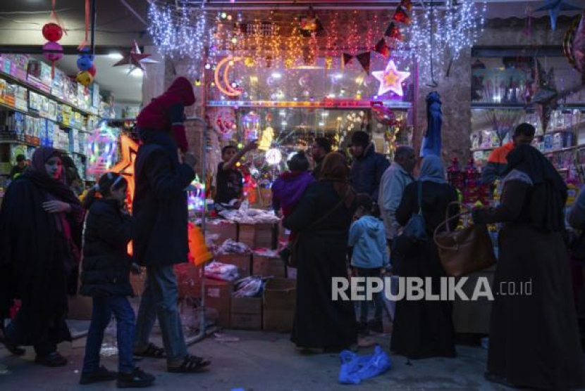 Warga Palestina berbelanja lampu dan dekorasi lainnya di Pasar Zawiya menjelang bulan suci Ramadhan, di Kota Gaza,Selasa (21/3/2023). Sumber: AP Photo/Fatima Shbair, file (Republika.co.id)