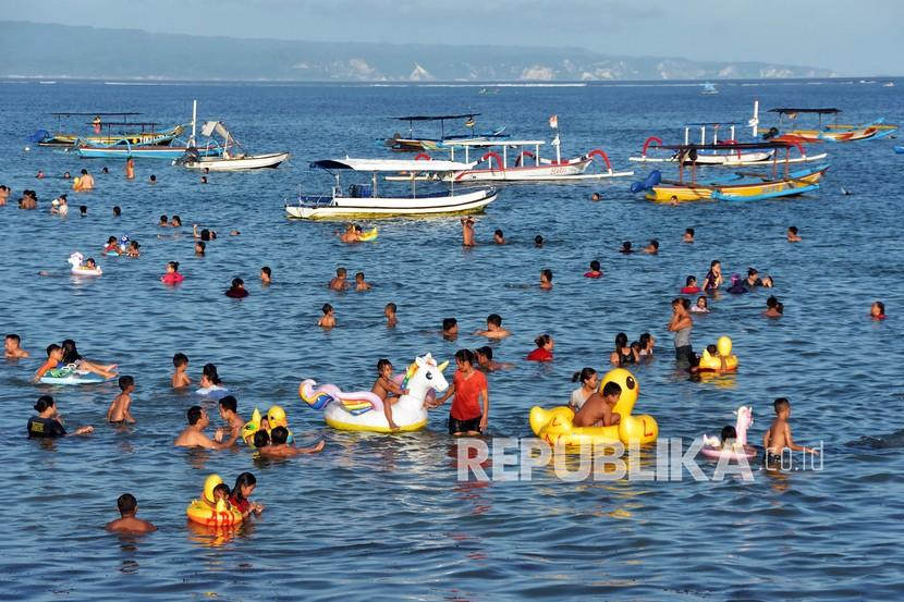 Wisatawan menikmati liburan di pantai. Antara/Nyoman Hendra Wibowo