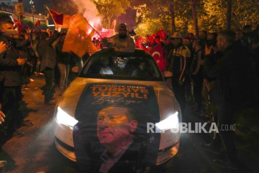 Pendukung Presiden Recep Tayyip Erdogan bersorak di luar markas AKP (Partai Keadilan dan Pembangunan) di Istanbul, Turki, Senin dini hari (15/5/2023). Lebih dari 64 juta orang, termasuk 3,4 juta pemilih luar negeri, berhak memilih. Sumber:AP Photo/Khalil Hamra. file (Republika.co.id)